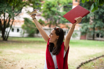 Fototapeta na wymiar Portrait of an happy teenager raising her arms