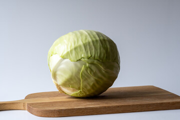 White cabbage head on a kitchen board, ready for food preparation