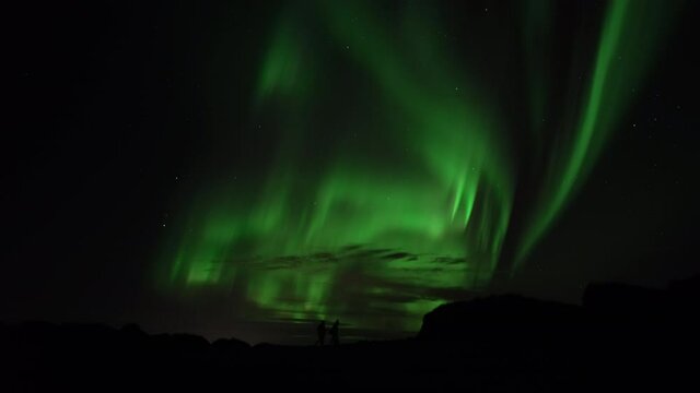 People walking under active aurora borealis real-time video
