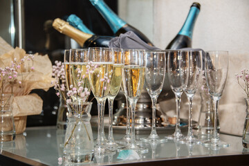 A row of champagne glasses on a glass table at a celebration
