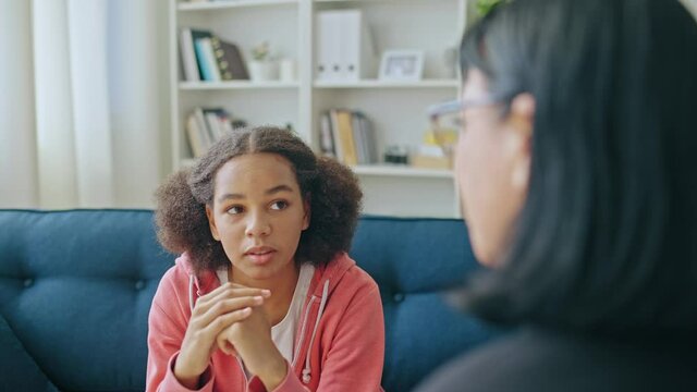 Teenager talking to female psychologist, adolescent counseling, mental health
