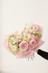 Colorful flowers assorted bouquet in bright paper. Holiday celebration concept. Bouquet of beautiful flowers in hands. Colorful flowers bouquet wrapped in paper