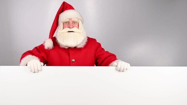Santa Claus peeks out from behind an ad on a white background. Merry Christmas.