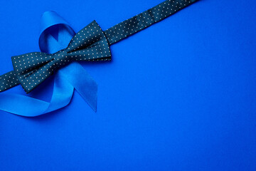 Blue prostate ribbon. Awareness prostate cancer of men health in November. Blue ribbon, fashion bowtie isolated on deep blue background. November and International Mens Day.