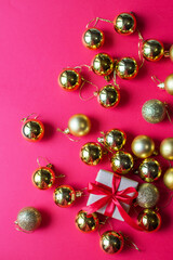 Festive concept - a gift with a bow and Christmas toys on a red background. composition for christmas, new year and holidays. flat lay with place for text.
