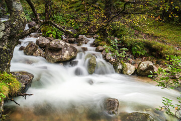 Obraz premium An autumnal 3 shot HDR image of lower Allt Coire Eoghainn in flood after heavy rain in Glen Nevis, Lochaber, Scotland.