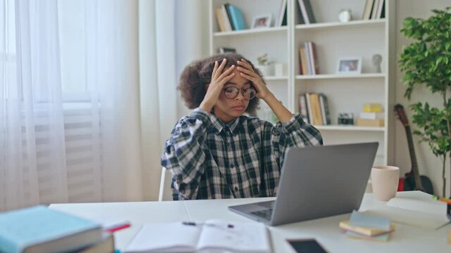 Upset school pupil reading bad news on laptop, low marks in exam, disappointment