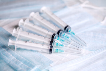 Five medical syringes are on the table. Disposable syringes and medical masks. Consumables for...