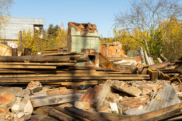 Photo of ruin of an old red brick house against the background of garbage, rubbish and junk on the street