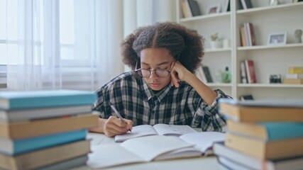 Tired college student in eyeglasses doing homework, academic stress, education