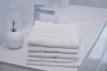 Obraz na płótnie Canvas Blurred bathroom interior background and white spa towels on sink. White towel shower in bathroom. 