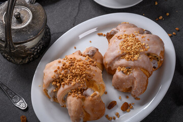 Tasty traditional polish croissants  - Croissant of Saint Martin (Rogal Swietomarcinski) with white poppy seeds, nuts and cup of coffee on a dark slate stone