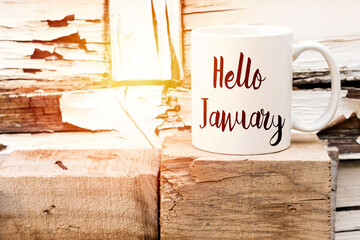 text Hello January on cup of aromatic coffee on wooden cube © hadjanebia