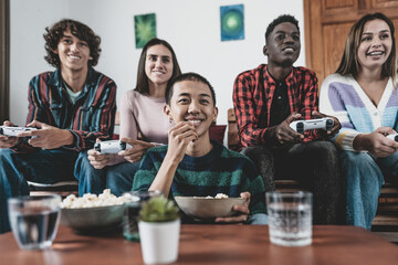 Young multiracial teenagers playing online video game console at home - Youth people addicted to...