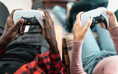 Top view of young multiracial teenagers playing online video game console at home - Youth people addicted to new technology gaming entertainment