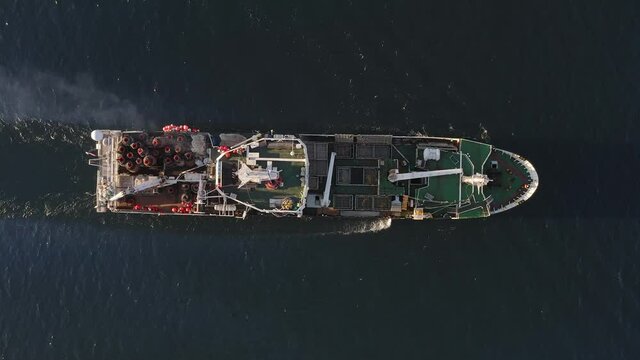 View from the drone vertically down on a fishing trawler at sea on the move