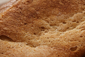 Fresh crusty bread with a golden crust up close. Background, texture.