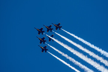 Group of flying aircrafts against a blue sky during an airshow