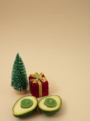 Christmas scene, creative winter accessories gift box, christmas tree on   color background.  New year and xmas decoration concept with copy space. Minimal colored and avocado with green candles