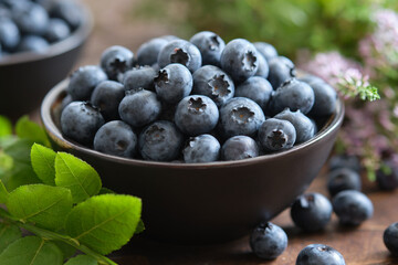 Bowl of fresh ripe blueberries on kitchen table.