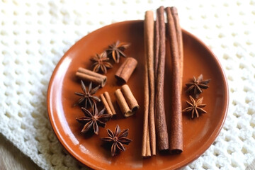 Plate of various winter spices and knitted blanket. Selective focus.