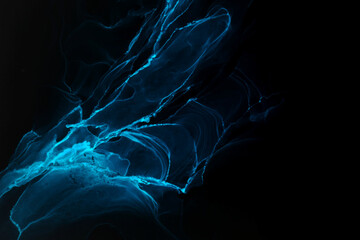 Abstract blue electric wave on black technology background. Neon light paint in water, acrylic...