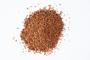 Freeze-dried instant coffee on white background close-up. Heap of powdered brown coffee product scattered on the table
