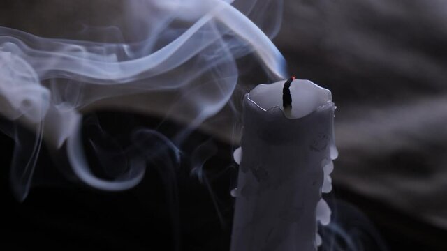  White candle wick blow out. and old book on a wooden table 