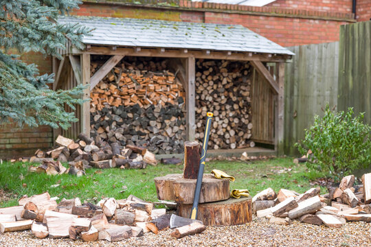 Chopping firewood, log store in UK garden