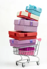 Fotobehang Lieve mosters Kleurrijke geschenkdozen in een winkelwagentje op witte achtergrond. Jaarlijks verkoop winkelseizoen concept