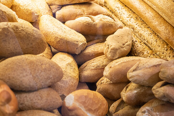 Fototapeta na wymiar Fresh baked bread background, variety of different kind of bread in bakery