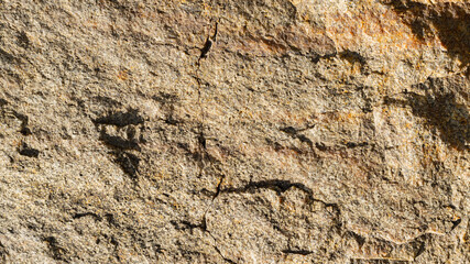 Texture of granite rock. Cracked stone surface from weathering. Close up of granite surface. Earth color concept