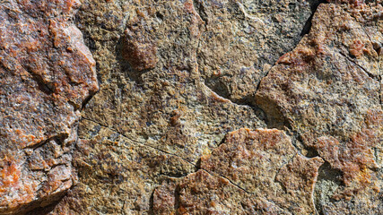 Texture of granite rock. Cracked stone surface from weathering. Close up of granite surface. Earth color concept