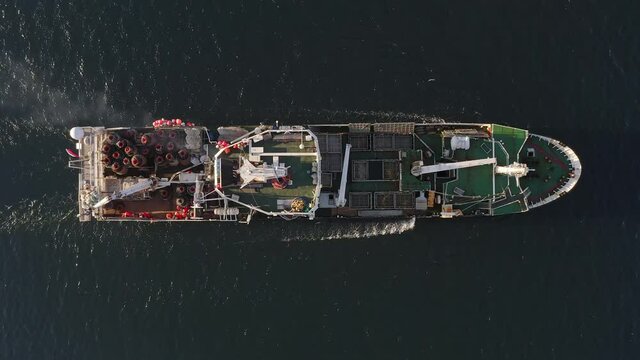 View from the drone vertically down on a fishing trawler at sea on the move