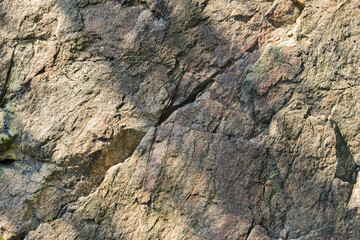Texture of granite rock. Cracked stone surface from weathering. Close up of granite surface. Earth color concept