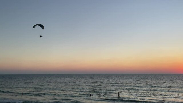 Power paraglider over the sea at sunset time. 4K