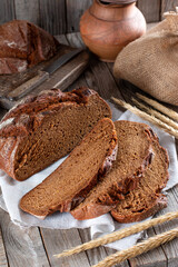 Bread, traditional sourdough bread cut into slices on a rustic wooden background. Concept of traditional leavened bread baking methods.