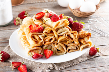 Pancakes with strawberries close-up. Maslenitsa. Thin freshly baked pancakes with strawberries.