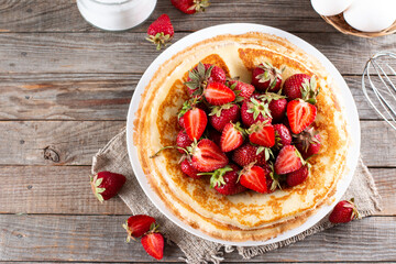 Pancakes with strawberry, traditional for Shrove Tuesday on table. Top view. Copy space