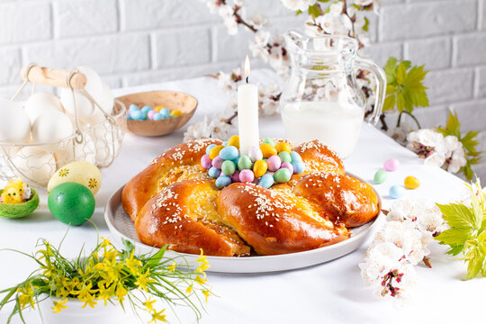 Happy Easter. Sweet Easter bread with colored eggs and flowers.