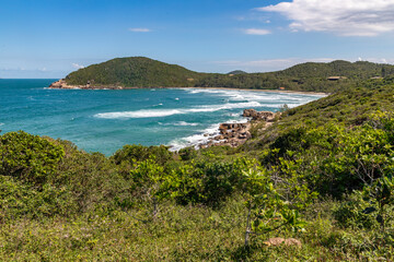 Fototapeta na wymiar Beach view with vegetation, rocks and mountains