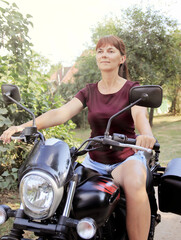 Fototapeta na wymiar Woman driving a motorcycle outside the city
