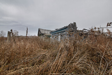 An abandoned village in Russia. A crumbling wooden clapboard house.