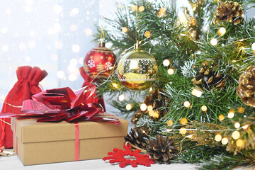 Merry Christmas. Christmas gifts and surprises on a white wooden table next to branches of a Christmas tree and shining lights. Greeting card or banner for website