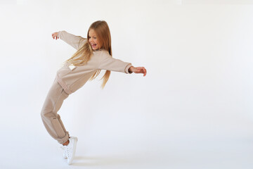 Girl dancing and laughing in a beige suit