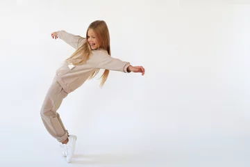 Foto op Plexiglas Girl dancing and laughing in a beige suit © Zarya Maxim