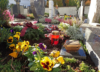Schön geschmückte Gräber auf einem Friedhof an Allerheiligen - obrazy, fototapety, plakaty
