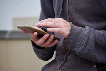 Hands using a mobile phone outside