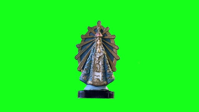 Souvenir of the Virgin Mary Against a Chroma Background. Close Up. You can replace green screen with the footage or picture you want with “Keying” effect in After Effects. 4K Resolution.