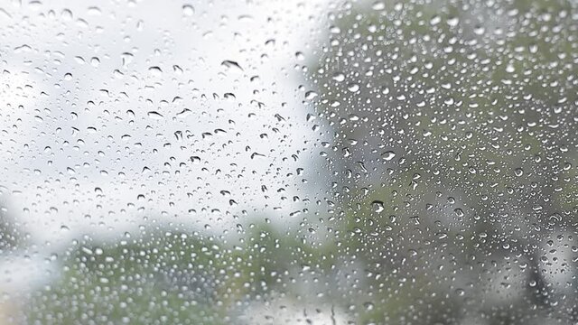 Gotas de agua cayendo sobre el vidrio de un coche. la lluvia cae sobre la ventana. El agua cae en días lluviosos.